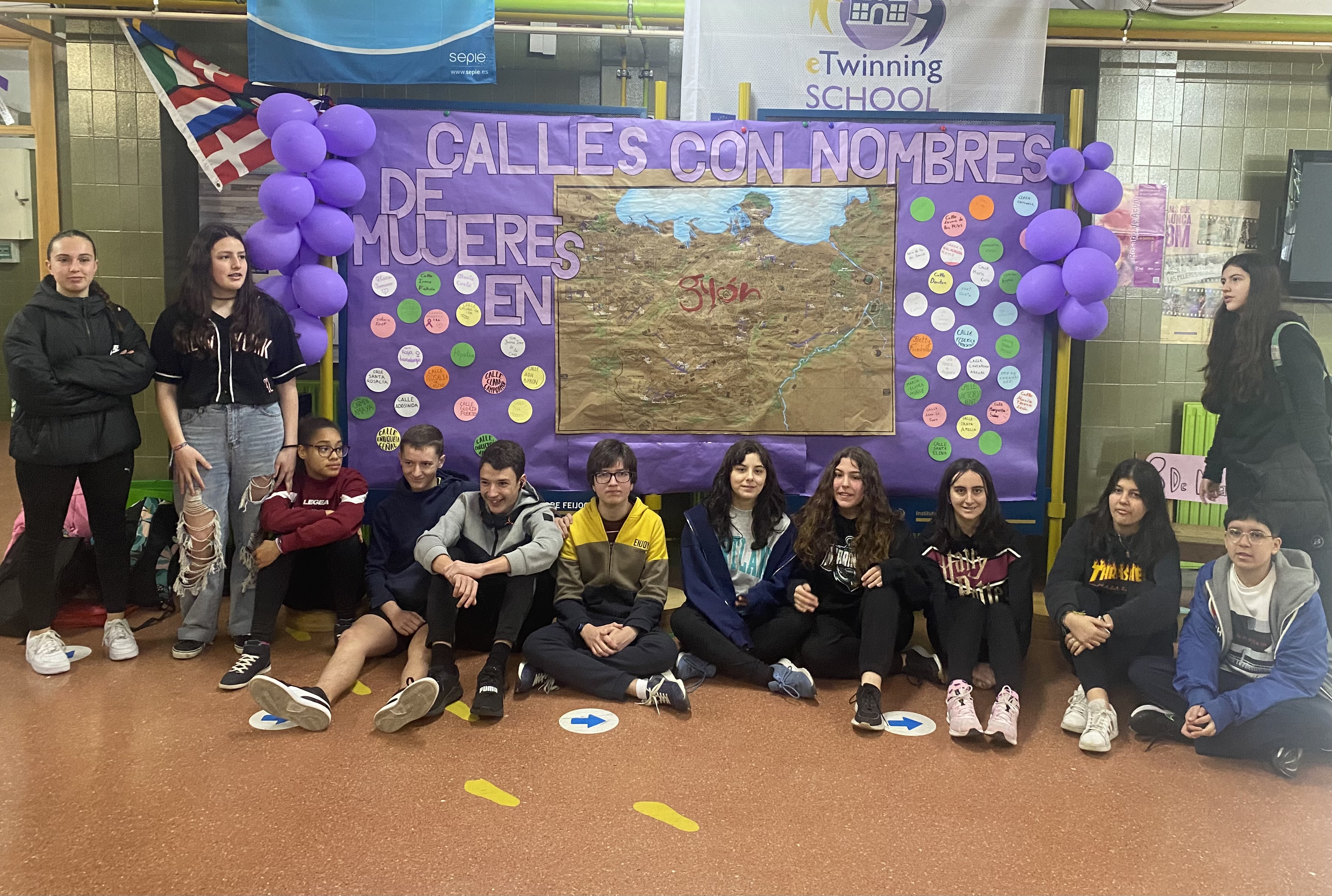 Grupo 3C con cartel 8M